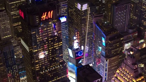 AERIAL: Times Square adorned with brightly lit advertisement billboards at night Stock Footage
