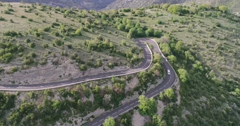Aerial top down 4k view of cars driving on a curvy road on the mountain Stock Footage 196307057