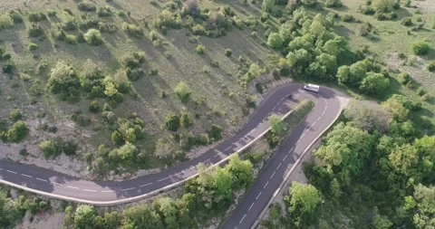 Aerial top down 4k view of cars driving on a curvy road on the mountain Stock Footage 196307330