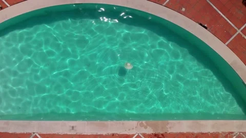 Aerial top down approaching view of woman's summer hat floating on pool  Stock Footage 196022993