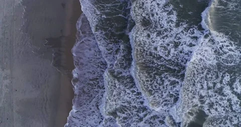 Aerial top down of beach and waves of teal water flowing to the coast Stock Footage 232029592