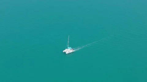 Aerial top-down of catamaran sailing in open turquoise water Stock Footage 310622857