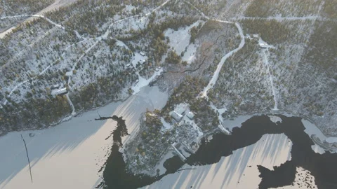 Aerial Top Down Circling Drone Shot Of Small Cabins At Frozen Lake Sunset Stock Footage 224251998