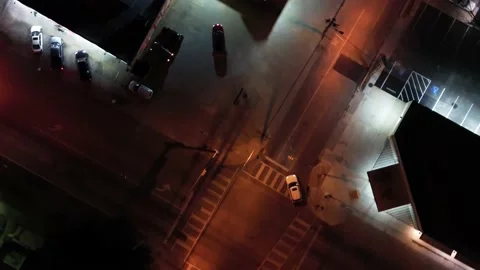 Aerial Top Down City Intersection at Night with Cars Driving Through Stop Lights Stock Footage 230181799