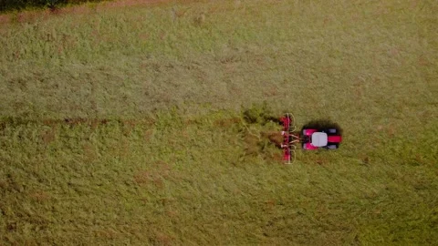 Aerial top down clip of Tractor turning the hay in the English Countryside Stock Footage 197596826