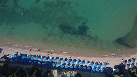 Aerial top down close up shot of rows of blue umbrellas on a beach. Stock Footage 343939925