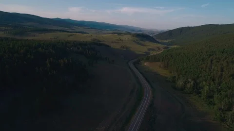 AERIAL, TOP DOWN: Dark colored car driving down an asphalt road crossing the Stock Footage 125466416