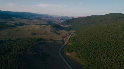 AERIAL, TOP DOWN: Dark colored car driving down an asphalt road crossing the Stock Footage 125466456