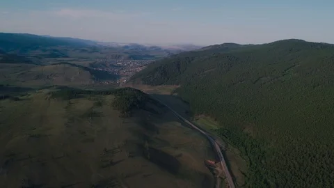 AERIAL, TOP DOWN: Dark colored car driving down an asphalt road crossing the Stock Footage 125466559