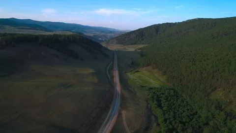 AERIAL, TOP DOWN: Dark colored car driving down an asphalt road crossing the Stock Footage 125466682