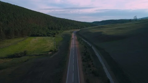 AERIAL, TOP DOWN: Dark colored car driving down an asphalt road crossing the Stock Footage 125466744