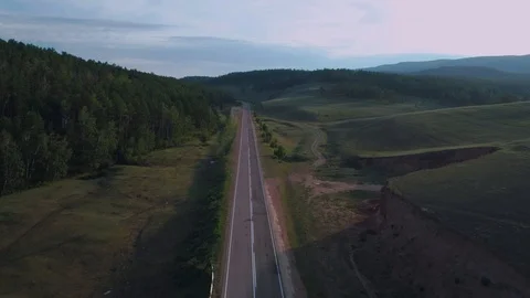 AERIAL, TOP DOWN: Dark colored car driving down an asphalt road crossing the Stock Footage 125466790