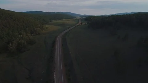 AERIAL, TOP DOWN: Dark colored car driving down an asphalt road crossing the Stock Footage 125466867