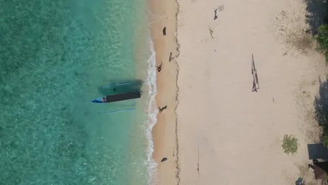 Aerial top down descent of small boat on beach and turquoise water Stock Footage 340158673