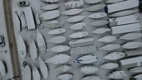 Aerial top down drone landscape of snow covered boats on an icy winter day .. 스톡 동영상 243849696