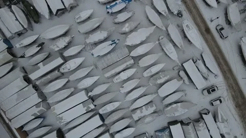 Aerial top down drone landscape of snow covered boats on an icy winter day .. 스톡 동영상 243849707
