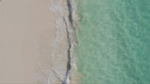 Aerial top down drone shot of Caribbean sea lapping onto sandy beach Stock Footage 137503353