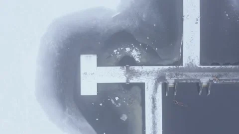Aerial top down drone shot of a person swimming in frozen lake Stock Footage 146295102