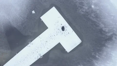 Aerial top down drone shot of person standing at the end of a snowy boardwalk Stock Footage 146295311