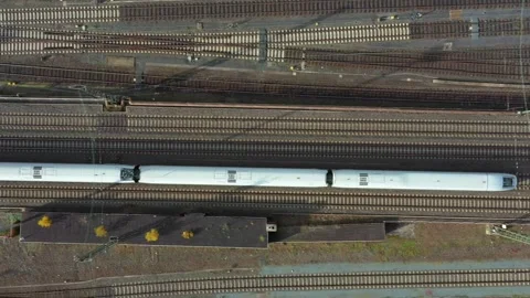 Aerial top-down drone shot. Passenger train leaving a railway station. Stock Footage 253818909