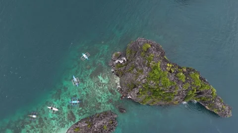 Aerial top down drone shot of rocky mountain in the middle of the ocean Stock Footage 291634821