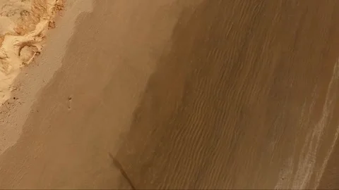 Aerial top-down drone shot of textured sand patterns on a beach in Casamance, Se Stock Footage 309913723