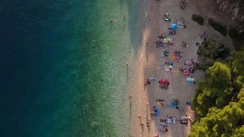 Aerial Top-Down Drone Shot of a Rocky Beach in Croatia with People Swimming and Stock Footage 320145916