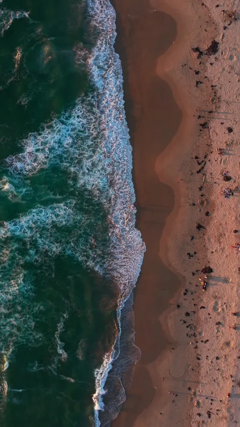 Aerial top-down drone shot of ocean waves crashing on a sandy beach shore, .. Video stock 339210588