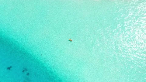 Aerial top down drone video following kayak, paddling in turquoise blue water Stock Footage 239823689