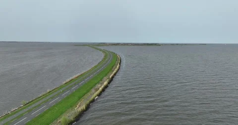 Aerial top down drone video on driving road surrounded by nature and water 스톡 동영상 274155848