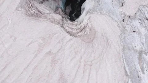 Aerial Top Down Drone view of Iceland Glacier cave hole with melting ice stream Stock Footage 240144380