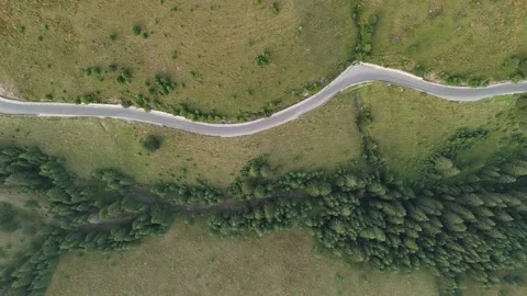 Aerial top down drone view of curvy road leading trough mountain environment Stock Footage 280332609