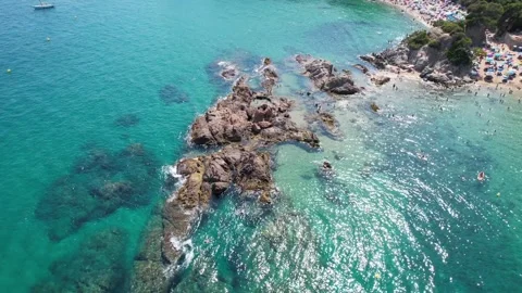 Aerial top-down drone view of kids playing on rocks in the Mediterranean Stock Footage 317609884