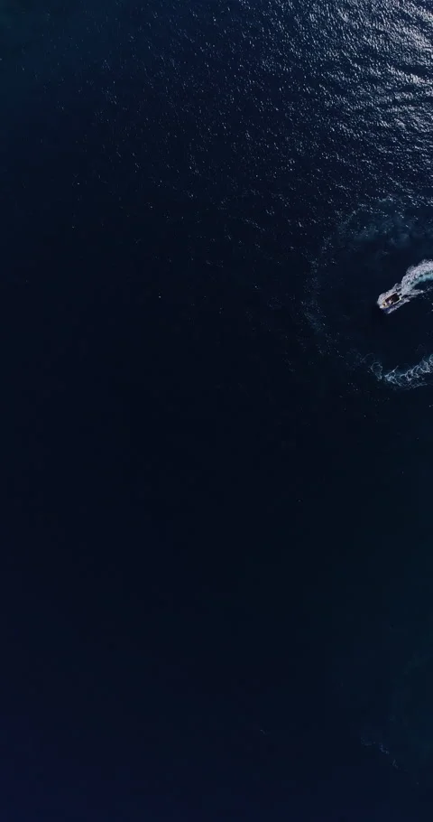 Aerial top down drone view of a speedboat forming an infinity loop on blue ocean Stock Footage 321228476