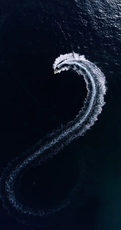 Aerial top down drone view of a speedboat forming an infinity loop on blue ocean Stock Footage 321228521