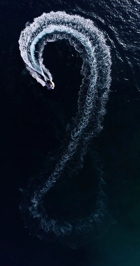 Aerial top down drone view of a speedboat forming an infinity loop on blue ocean Stock Footage 321228582