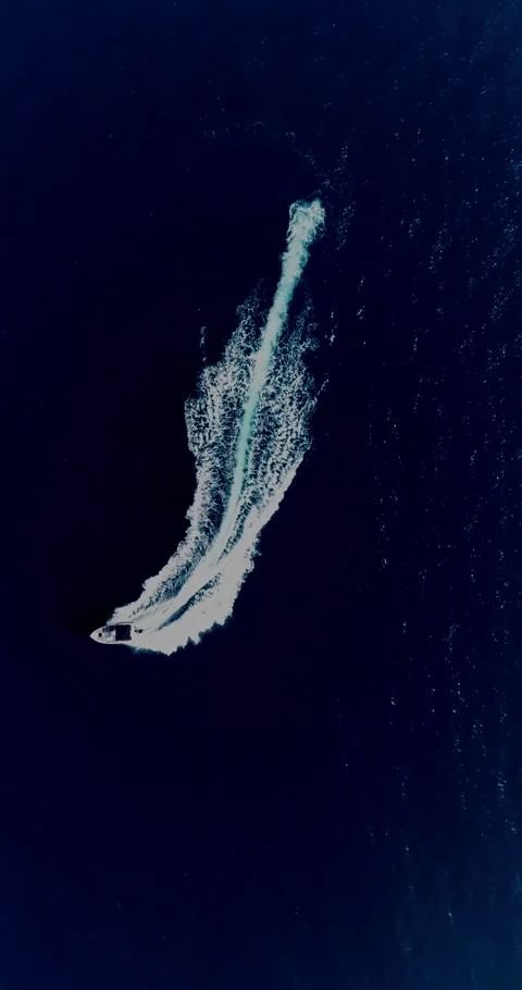 Aerial top down drone view of a speedboat forming an infinity loop on blue ocean Stock Footage 321228683