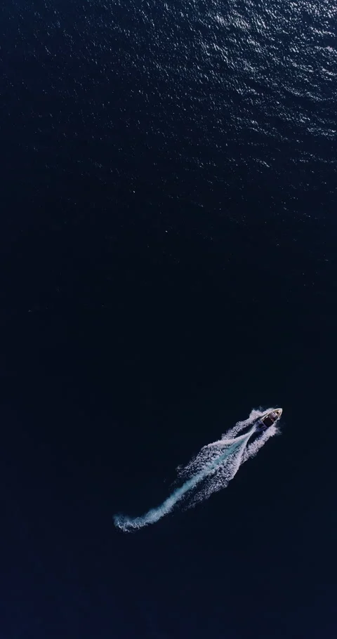 Aerial top down drone view of a speedboat forming an infinity loop on blue ocean Stock Footage 321232751