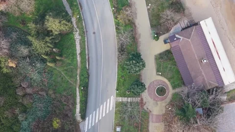 Aerial top-down drone view of curved road and small building Stock Footage 322537085
