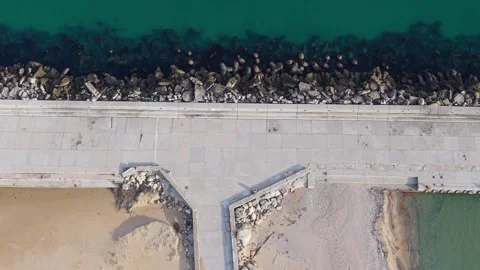 Aerial top-down drone view of concrete pier and rocky breakwater Stock Footage 322537369