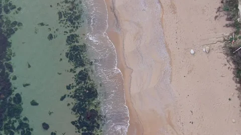 Aerial top-down drone view of sandy beach and shallow coastline Stock Footage 322901974