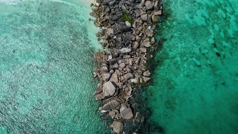Aerial, Top down: Fly over natural rocky outcrop in tropical ocean. HD50p Stock Footage 244391511