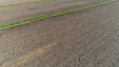 Aerial top down flying low altitude and sideways over dark brown soil 4k Stock Footage 75456900