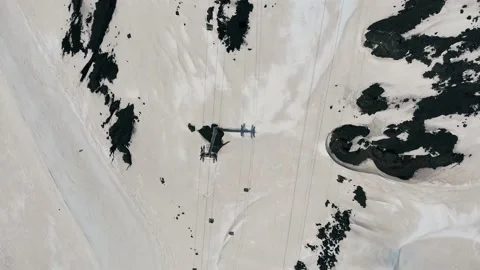 Aerial top down flyover shot of ski slope and cable car on snow-covered mountain Stock Footage 169036598