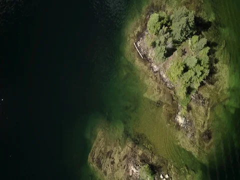 Aerial top down flyover of small island in a lake Video stock 79850392