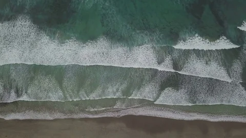 Aerial top down footage fixed camera with upcoming waves on the coast line Stock Footage 85303418