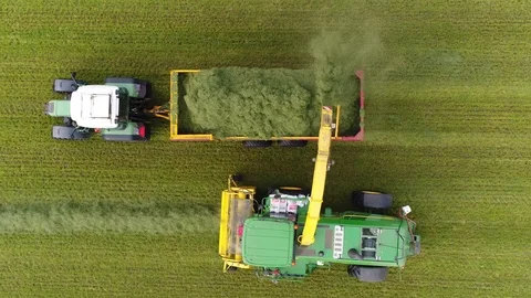 Aerial top down footage modern combine harvester unloading dried grass 4k Stock Footage 100982053