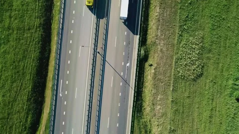 Aerial top down of highway through green meadows with traffic on it on a bright Stock Footage 252284510