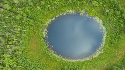 Aerial top down hyperlapse round lake. Cloudy sky reflected in turquoise water Stock Footage 136387275