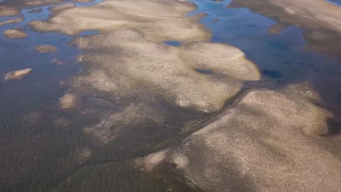 Aerial top down of low tide inlet with reflective water, 4k drone Stock Footage 253345668